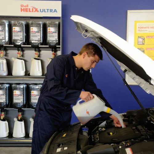 garagiste qui met de l'huile moteur